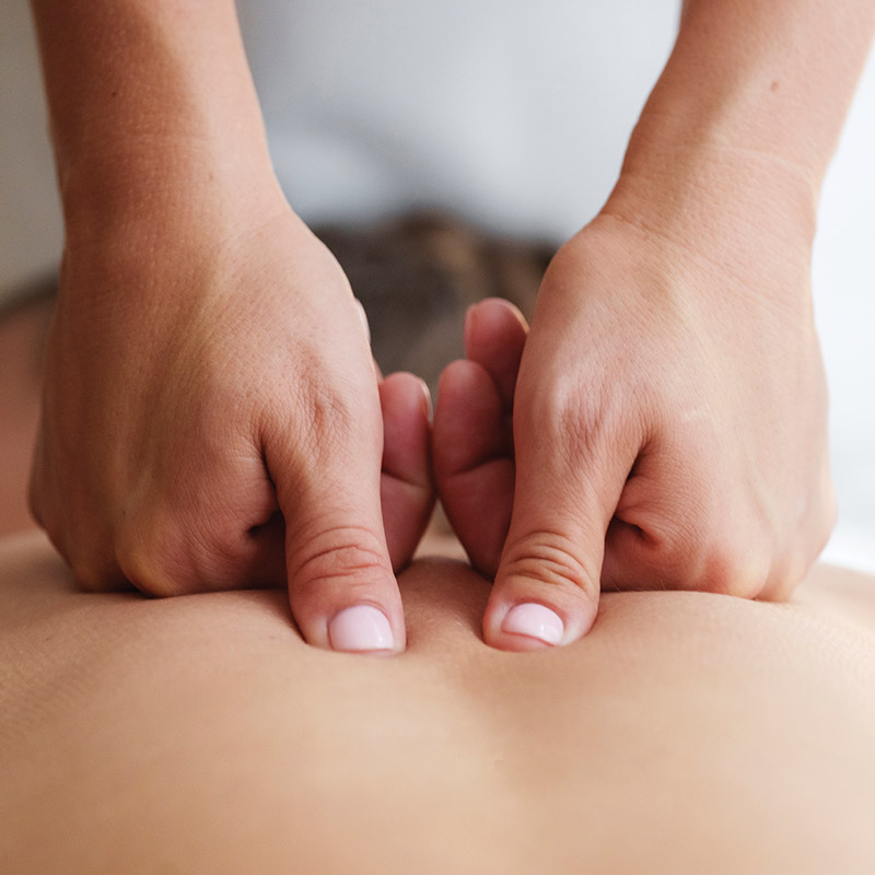 Hands kneading a person's back relieving pain and adding comfort.